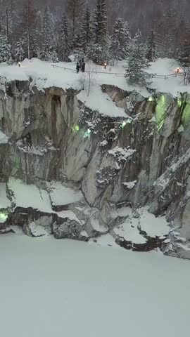 Marble kanyon, snowy lake, in Ruskeala, Karelia in winter, Russia 4k Ultrahd drone footage. Vertical shot.