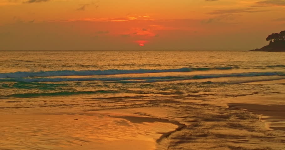 As the sun dips toward the horizon, the beach transforms into a canvas of vibrant hues. Streaks of orange, pink, and gold stretch across the sky, blending seamlessly with wisps of vivid clouds.