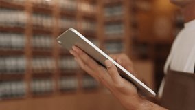 Closeup hands of professional waiter touching screen of tablet computer in cafe. Young man uses digital menu taking customer order in restaurant. Digital technology increases retail work - Powered by Shutterstock - Get 15% off with code: PIKWIZARD15