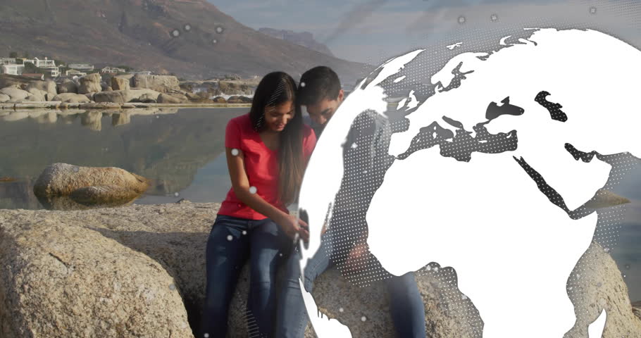 Seated couple leaning together on granite rock by tidal pool, displaying technology globe overlay. Scenic, tranquil, romance, outdoor, landscape, reflection, adventure