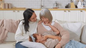 Asian multigenerational family grandmom mother and daughter nephew offspring and granddaughter smiling happily together at camera on sofa The love of a family makes life beautiful	 - Powered by Shutterstock - Get 15% off with code: PIKWIZARD15
