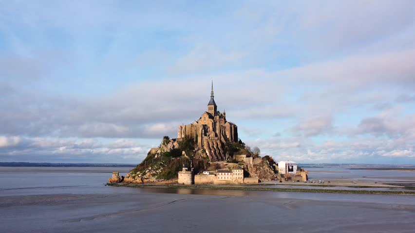 Wide aerial view of Mont Saint Michel with abbey and sandbanks at low tide