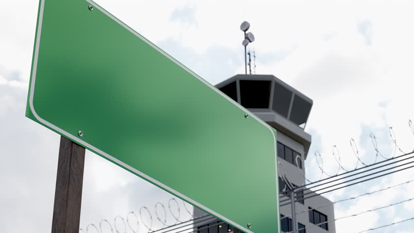 Blank Green Road Sign Ready for Your Message In Front of Air Traffic Control Tower.