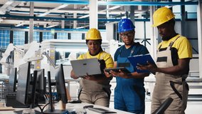 All black inspectors team in photovoltaics factory look over documents, review performance of robot arms placing solar panels on assembly lines. Supervisors inspecting solar cells plant. Camera B. - Powered by Shutterstock - Get 15% off with code: PIKWIZARD15