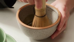 Matcha green tea cooking process, japanese powder green tea in a bowl with bamboo whisk, macro close up in cafe of powder green tea.  - Powered by Shutterstock - Get 15% off with code: PIKWIZARD15