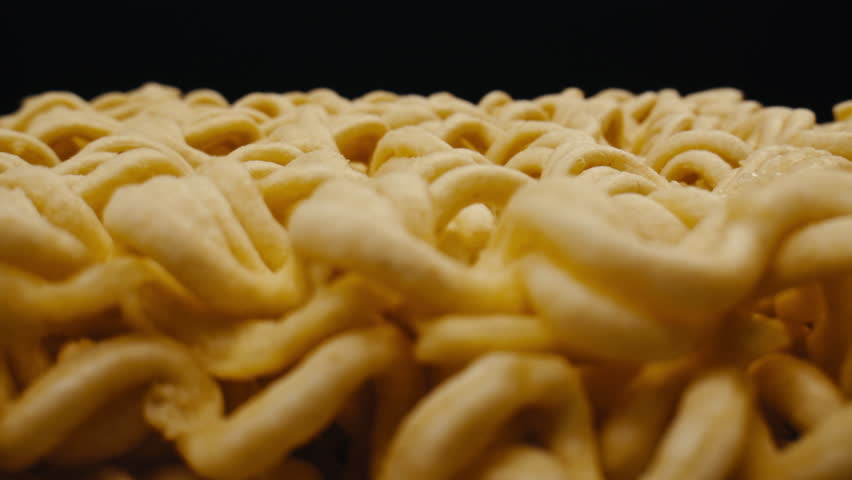 Cooking instant noodles in boiling water with spices close-up. Asian fast food. Instant noodles, or instant ramen, is a type of food consisting of noodles sold in a precooked and dried block with