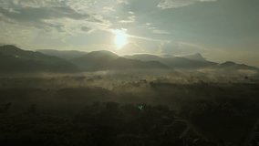 Aerial view of sunrise over mountainous landscape, with thick fog blanketing. Sun's golden rays pierce through mist, casting serene glow over the entire scene. - Powered by Shutterstock - Get 15% off with code: PIKWIZARD15