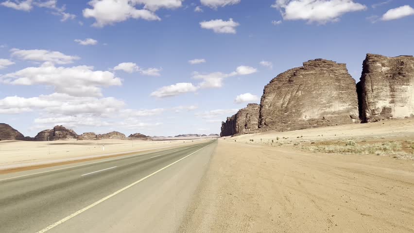 Desert Coastal Road on a Cloudy Day with Distant Cars