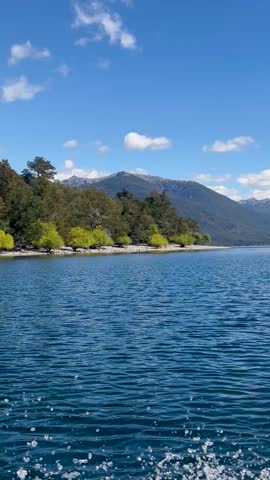 Lago Lacar Quila Quina in Argentina, clear blue water surrounded by lush green mountains