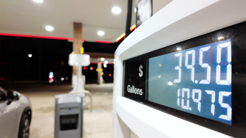 Close up footage of Petrol station with running numbers on gas pump at night time