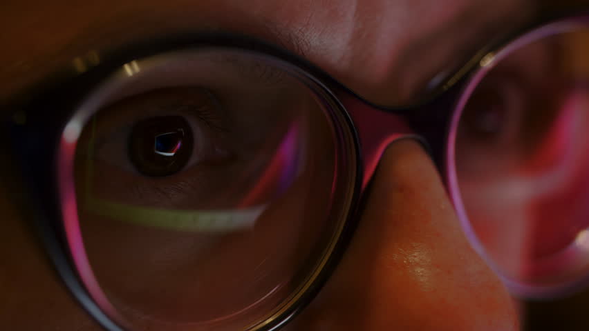The close up of woman eyes looking through glasses at flashing sliding lights