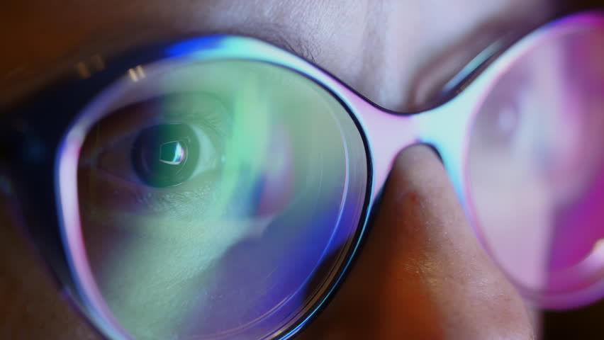 The close up of woman eyes looking through glasses at flashing sliding lights