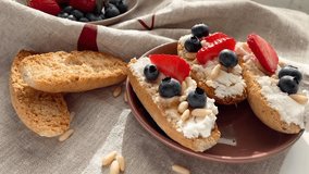 Crostini with ricotta, berries, pine nuts. Slices of toasted bread with cheese for breakfast. Healthy meal and snack. - Powered by Shutterstock - Get 15% off with code: PIKWIZARD15
