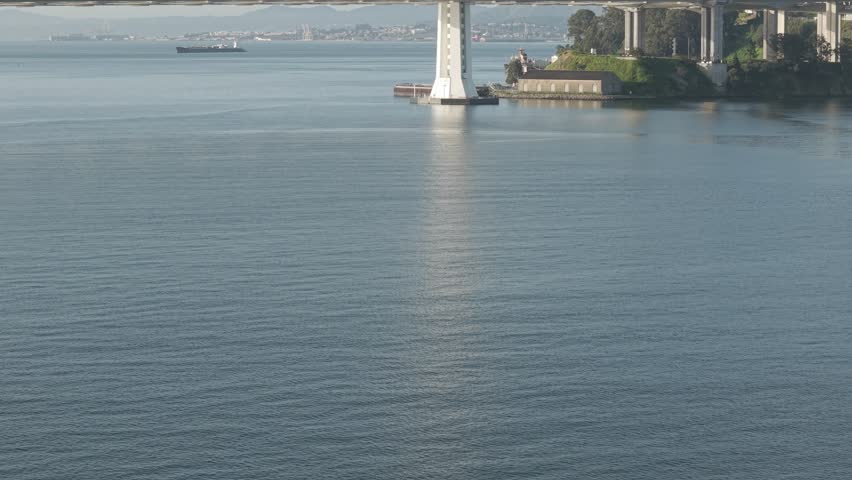 A drone gimbal panning upwards to reveal the San Francisco Bay Bridge.