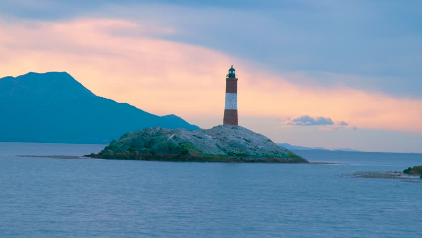 Les Eclaireurs Lighthouse stands on a rocky islet in the Beagle Channel near Ushuaia, Argentina, at sunset. Aerial drone view.