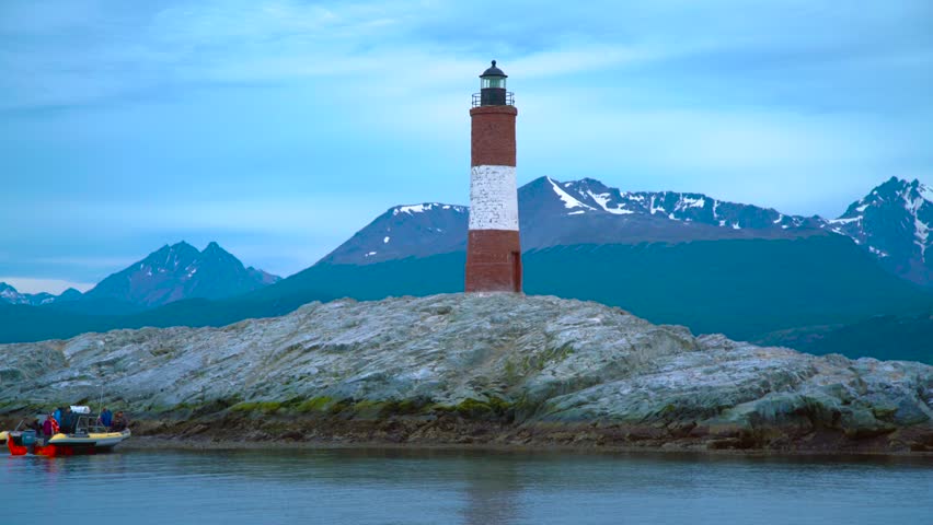 Les Eclaireurs Lighthouse on a rocky island in the Beagle Channel near Ushuaia, Argentina, with mountains in the background. Aerial drone view.