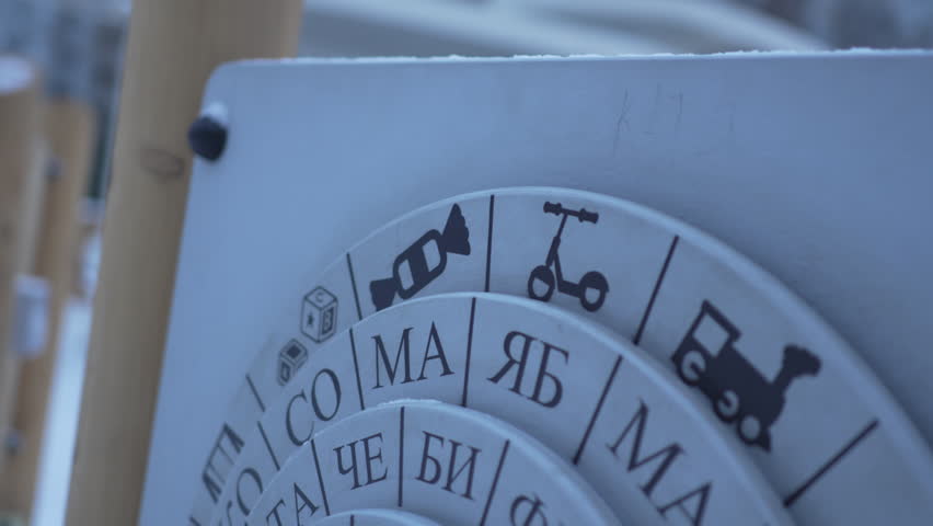 Educational puzzle with rotating circles shows colorful syllables for word creation. Preschool fun meets learning spelling outdoors