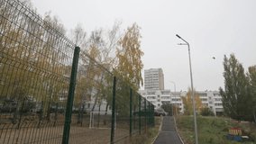 Metal fence frames quiet football field under autumn skies. Empty space feels still and reflective and Fall atmosphere colors every detail - Powered by Shutterstock - Get 15% off with code: PIKWIZARD15
