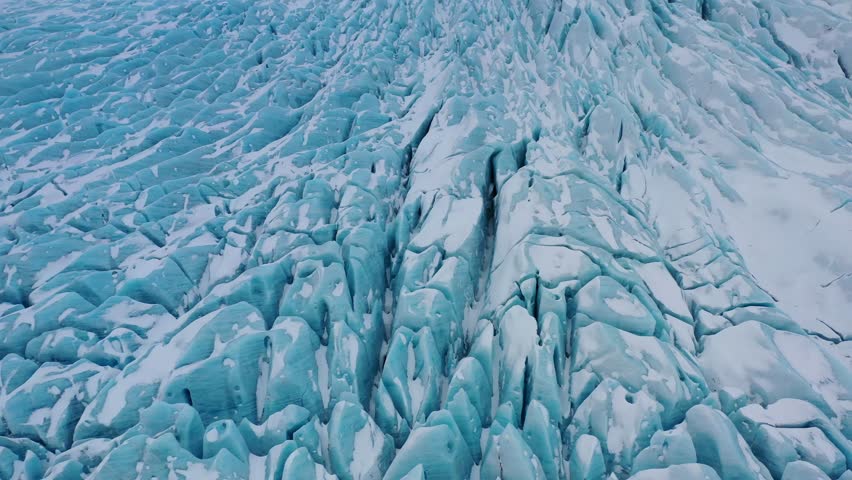 FPV aerial drone flying over icy blue glaciers. Above view of Glacier skaftafell, Vatnajokull National Park, Jokursalon Glacier lagoon. Iceland. Snow-covered ice cliffs Greenland.