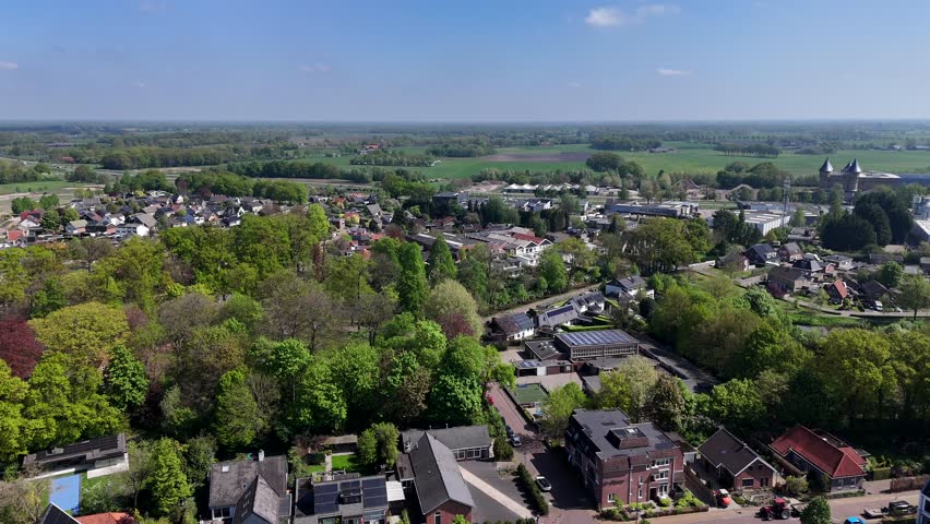 Colored Trees at river of american town. Aerial wide shot. Sunny day with blue sky and agricultural farm fields in distance. Houses and homes in small american town.
