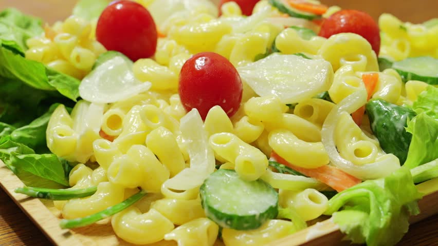 Macaroni salad with lots of tomatoes and other vegetables	