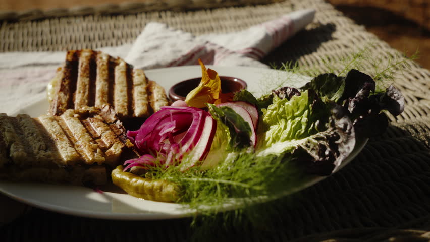 Delicious grilled sandwich with fresh salad. Perfect for culinary blogs or cooking shows.