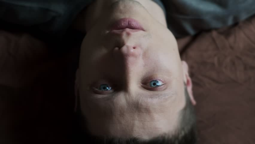 A blue-eyed young man cries. Close-up of emotional man crying with tears streaming down face. Heartbreak and emotional collapse