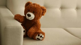 a stuffed toy bear sits on the sofa video - Powered by Shutterstock - Get 15% off with code: PIKWIZARD15