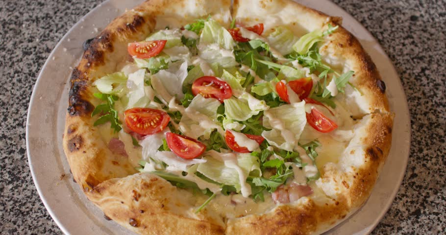 Close up shot of chef hands making pizza at kitchen Pizzaiola sprinkling with cheese pizza dough. Close up view of male hands cooking vegan pizza. Cafe or restaurant. Hands of male pizza baker.