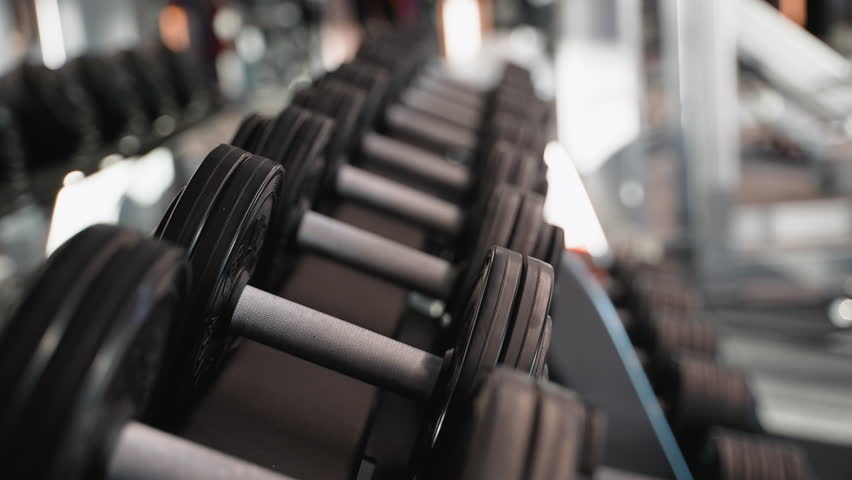 Man picking up dumbbell from rack in gym