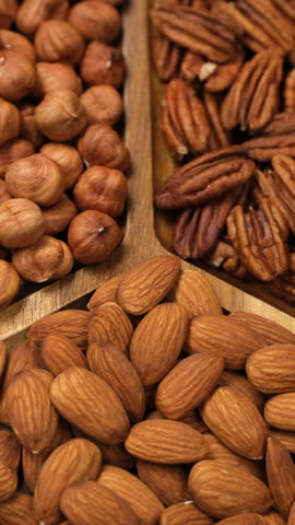 Dried nuts in wooden plate, rotate