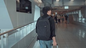 Rear view - Male traveler walking with luggage at the modern airport terminal, man on way to flight boarding gate, Ready for travel or vacation journey. - Powered by Shutterstock - Get 15% off with code: PIKWIZARD15