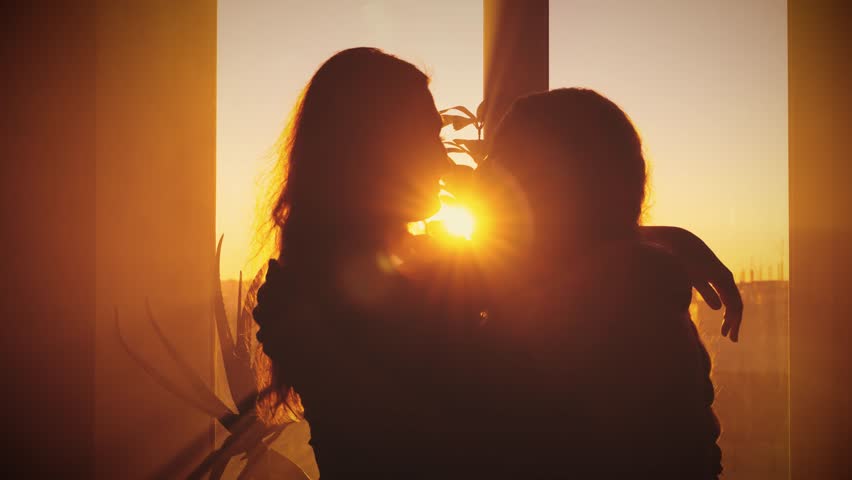 Dark silhouette two person hugging embracing each other in sun rays light warm flare. Concept of love family. Cozy Room window. Close-up couple adult woman daughter hugs old mother elderly senior lady - Powered by Shutterstock - Get 15% off with code: PIKWIZARD15