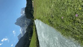 Swiss alpine river flowing through green meadows.Vertical video - Powered by Shutterstock - Get 15% off with code: PIKWIZARD15