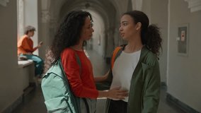Hispanic sad upset frustrated woman student walking in college university corridor hall girl female friend meeting talking supporting calming girls students hugging friendship help care problem school - Powered by Shutterstock - Get 15% off with code: PIKWIZARD15