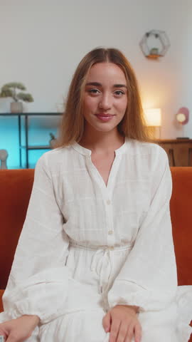 Successful rich Caucasian woman holding waving dollar bill money fan sitting on couch at home room. Happy excited adult girl winning online lottery game planning vacation calculating budget. Vertical.