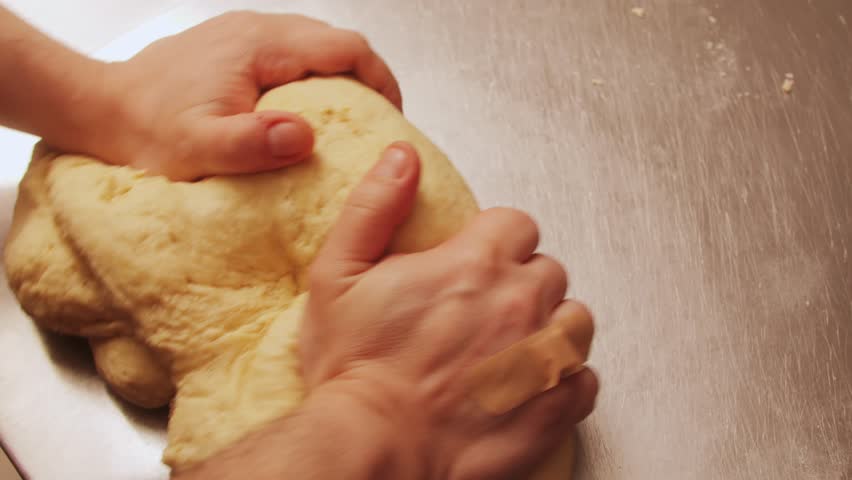 Man making dough Industrial Electric Spiral Dough Mixer Machine Kneading Bread Dough at the Bread Factory. 