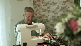 Senior man sewing camouflage fabric at home with sewing machine - Powered by Shutterstock - Get 15% off with code: PIKWIZARD15