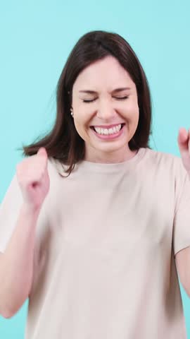 Excited woman celebrating success on turquoise background