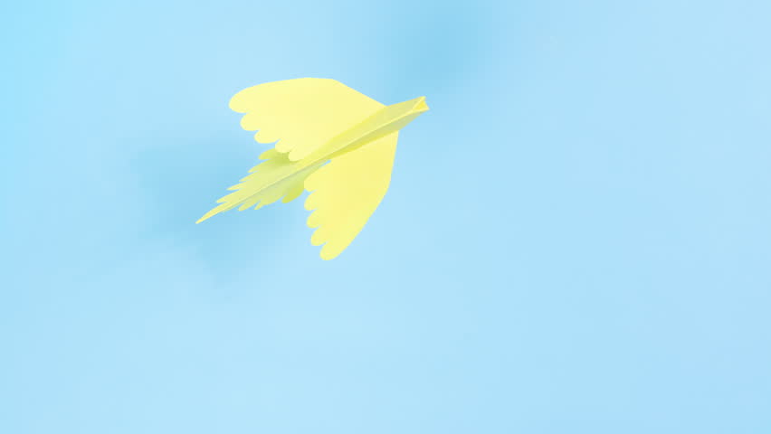 Yellow paper origami dove flies. Blue background. Symbol of peace. Concept of help, support and peace for Ukraine in fight against Russian aggression. Stop motion animation.  - Powered by Shutterstock - Get 15% off with code: PIKWIZARD15