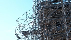 Scaffolding. Workers assembling complex scaffolding structure on a construction site. Crane operating overhead under clear blue sky, enhancing urban development dynamics - Powered by Shutterstock - Get 15% off with code: PIKWIZARD15