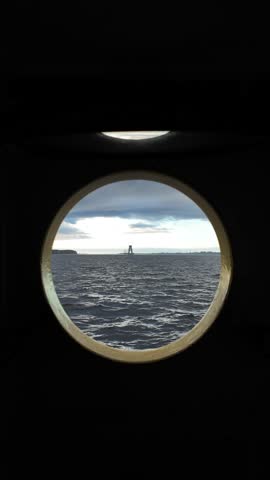 Ocean View through Circular Ship Window with Distant Boats
