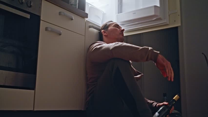 A Reflective Solo Moment in the Kitchen, capturing the essence of solitude and contemplation. depressed man sitting on the floor next to an open refrigerator drinking wine from a bottle