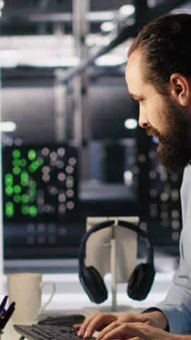 Vertical video Anxious technicians in data center reacting to system lockdown caused by ransomware alert. IT professionals under pressure evaluating security breaches and scrambling to contain damage