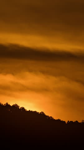 Breathtaking beauty of the sun rising time lapse video over a rugged mountain ridge on a cloudy morning.