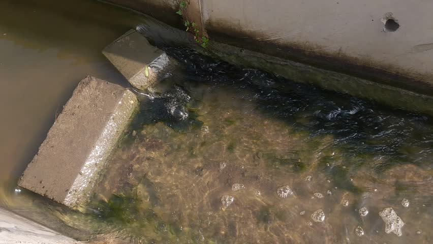 The modern irrigation channel made of concrete is blocked by concrete beams, thus hindering its flow.