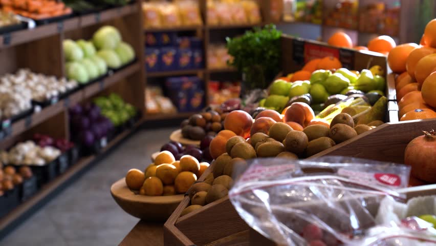 Assorted bins of colorful fruit and vegetables in market display, slow left-to-right pan.