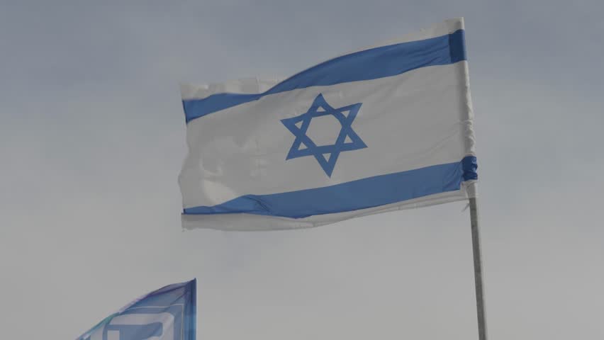 Israel national flag waving against sky, Closeup