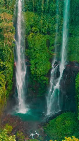 Aerial view of the majestic Sekumpul Waterfall cascading through lush green jungle in Bali, Indonesia.