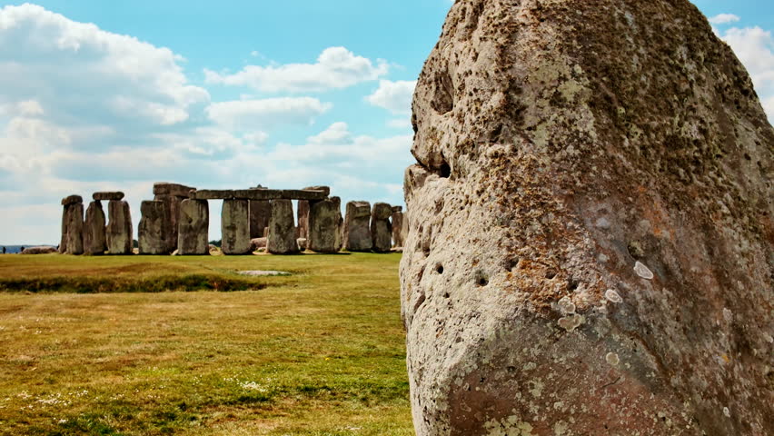 Stonehenge establishing shot uncovering weathered rock surfaces and precise stone alignments set on grassy terrain, Salisbury, Wiltshire, England, UK
